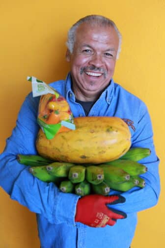 Omar holding fruit and smiling